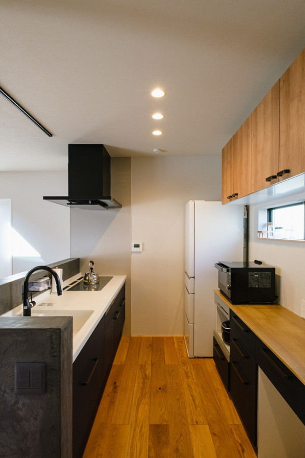 На фото: параллельная кухня-гостиная с паркетным полом среднего тона, синей столешницей и потолком с обоями с