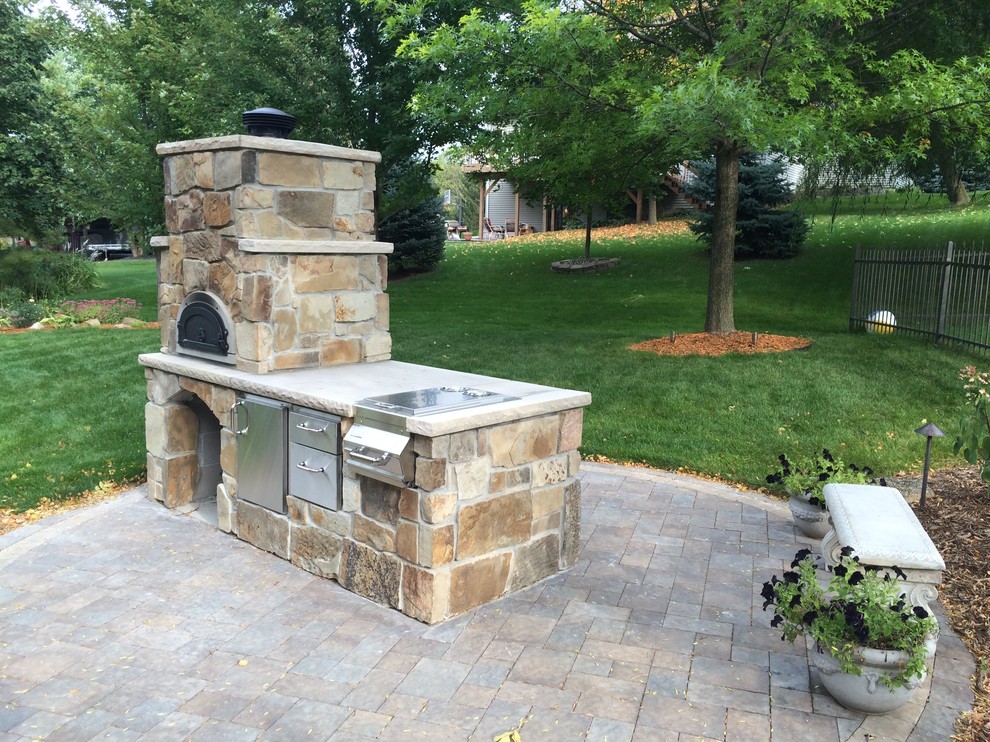 Inspiration for a small traditional backyard patio in Minneapolis with concrete pavers and an outdoor kitchen.
