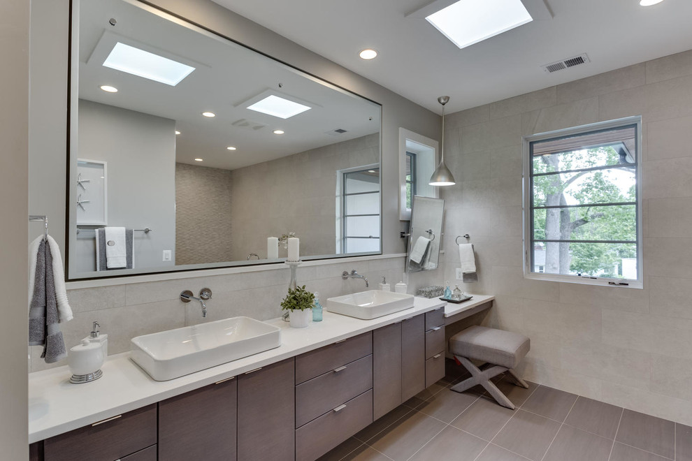 Photo of a large transitional master bathroom in Other with flat-panel cabinets, grey cabinets, a freestanding tub, grey walls, a vessel sink, solid surface benchtops and grey floor.