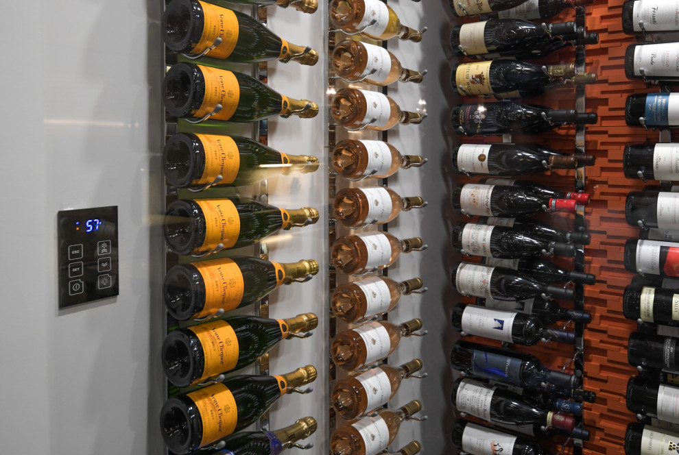 Cette image montre une cave à vin minimaliste de taille moyenne avec des casiers et un sol gris.