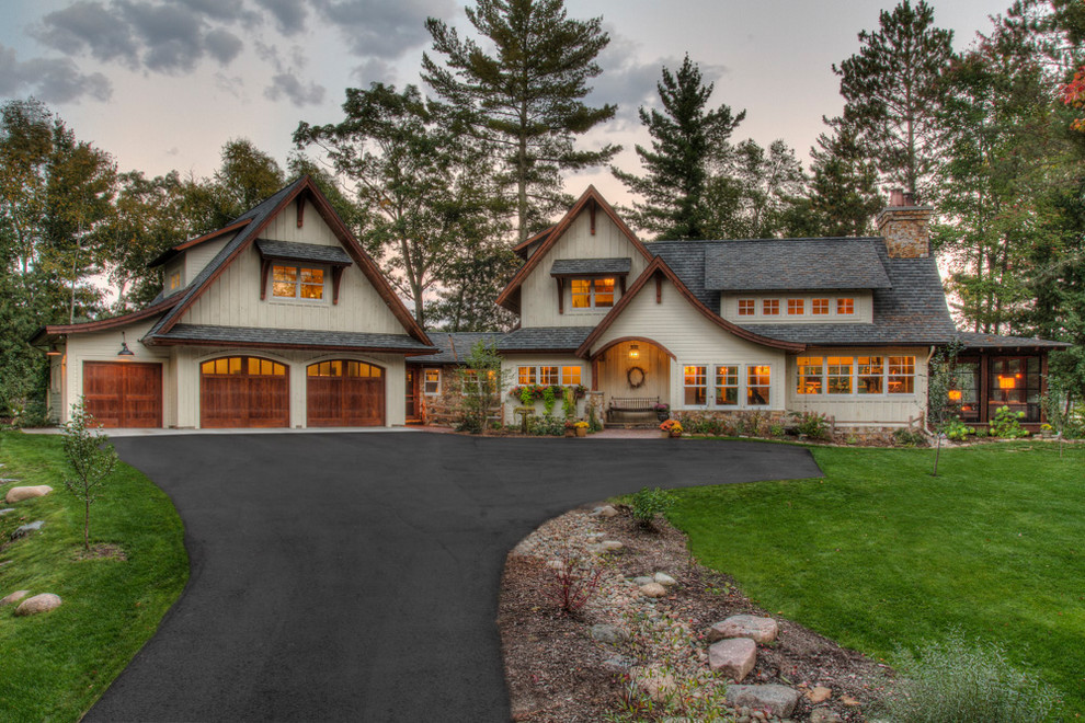 This is an example of a large country one-storey white house exterior in Minneapolis with wood siding, a gable roof and a shingle roof.