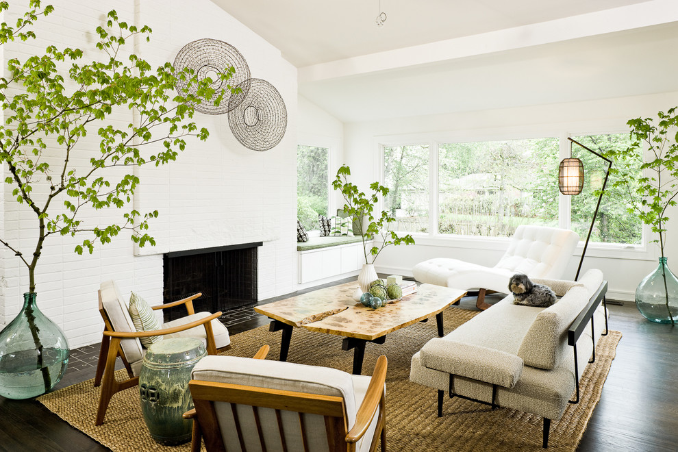 This is an example of a midcentury living room in Portland with white walls, a standard fireplace and a brick fireplace surround.