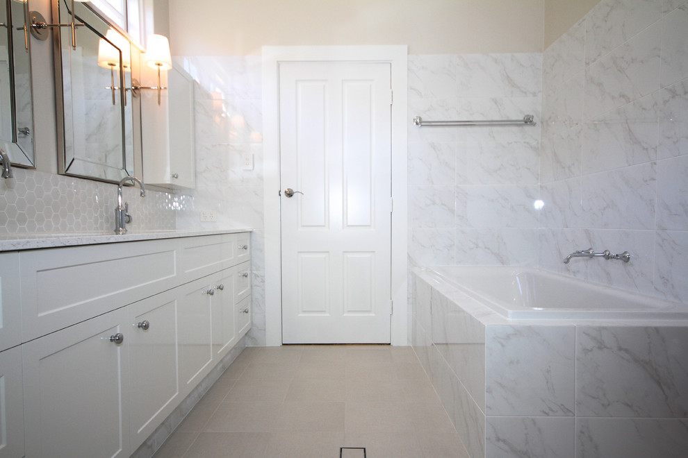 Inspiration for a traditional master bathroom in Perth with shaker cabinets, white cabinets, a drop-in tub, a one-piece toilet, white tile, an undermount sink, engineered quartz benchtops and a hinged shower door.
