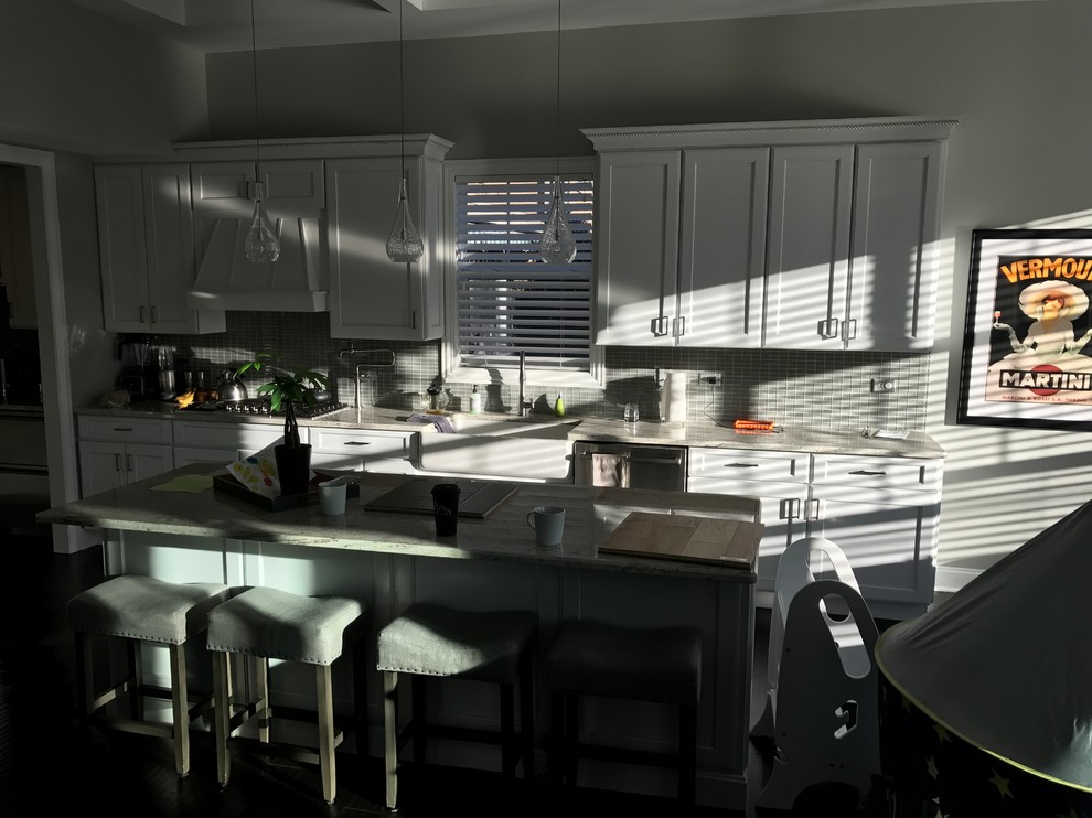 Example of a large transitional l-shaped light wood floor and multicolored floor eat-in kitchen design in Chicago with beaded inset cabinets, white cabinets, quartz countertops, black backsplash, ceramic backsplash, stainless steel appliances and an island
