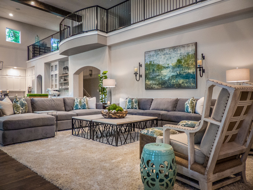 Inspiration for a large country open concept family room in Austin with grey walls, dark hardwood floors, a standard fireplace, a stone fireplace surround, a wall-mounted tv and brown floor.