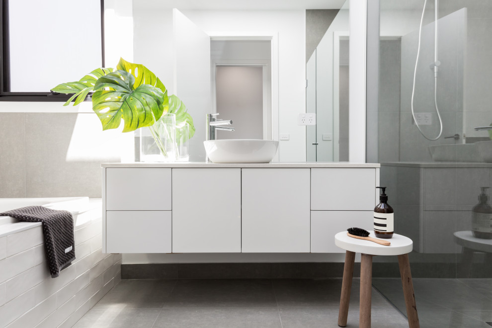 Contemporary bathroom in Melbourne with flat-panel cabinets, white cabinets, an alcove shower, white tile, white walls, a vessel sink, grey floor, grey benchtops, a single vanity and a floating vanity.