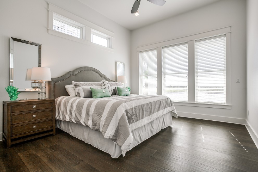 This is an example of a mid-sized transitional master bedroom in Austin with white walls, dark hardwood floors, no fireplace and brown floor.