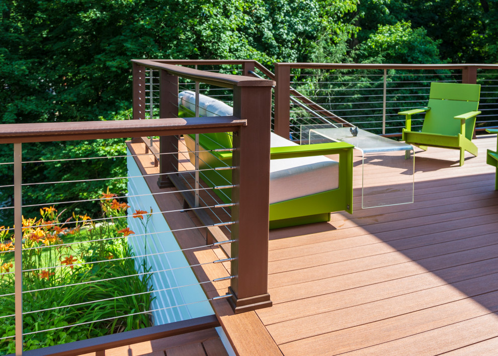 Photo of a mid-sized midcentury backyard and ground level deck in New York with cable railing.
