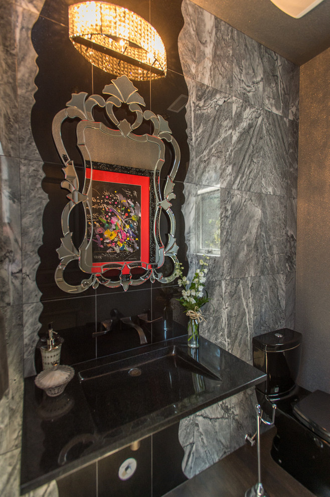 This is an example of a mid-sized transitional powder room in Vancouver with a pedestal sink, a one-piece toilet and dark hardwood floors.
