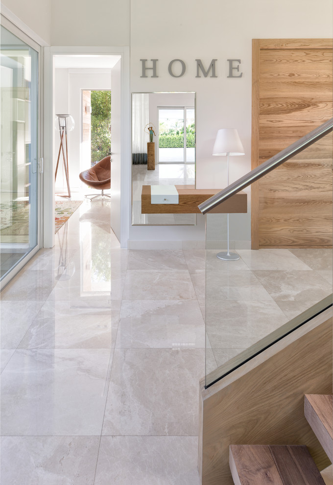 Design ideas for a large beach style foyer in Miami with grey walls, marble floors, a double front door, a light wood front door and beige floor.