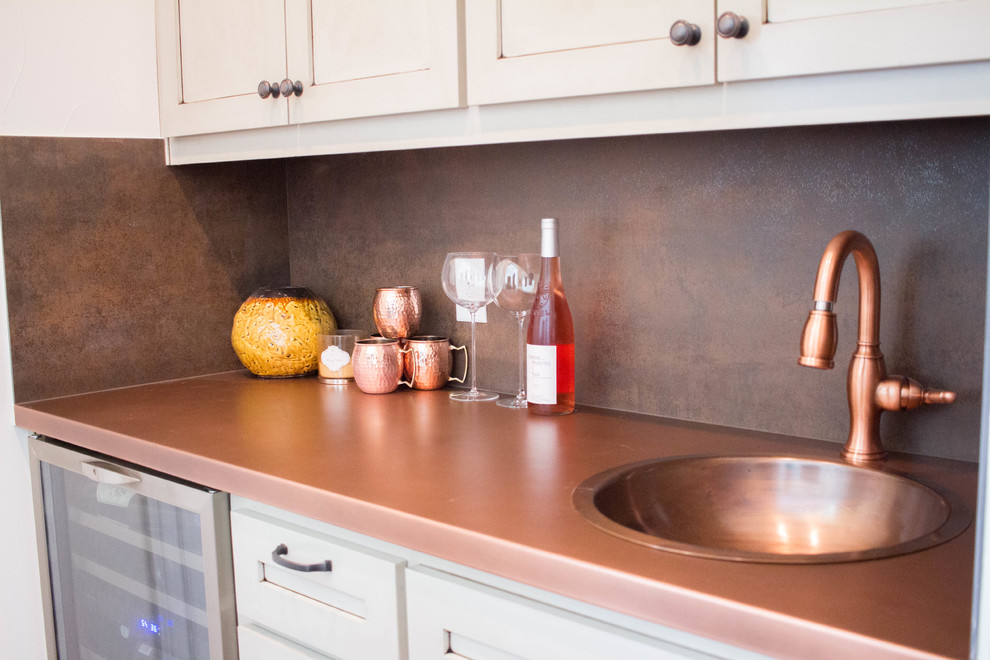 Design ideas for a mid-sized transitional single-wall seated home bar in Austin with white cabinets, copper benchtops, multi-coloured splashback, an undermount sink and shaker cabinets.