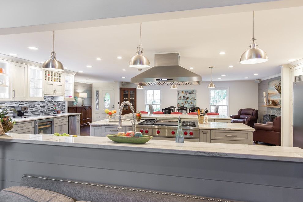 Large transitional single-wall medium tone wood floor and brown floor eat-in kitchen photo with an undermount sink, shaker cabinets, white cabinets, marble countertops, multicolored backsplash, matchstick tile backsplash, stainless steel appliances and two islands