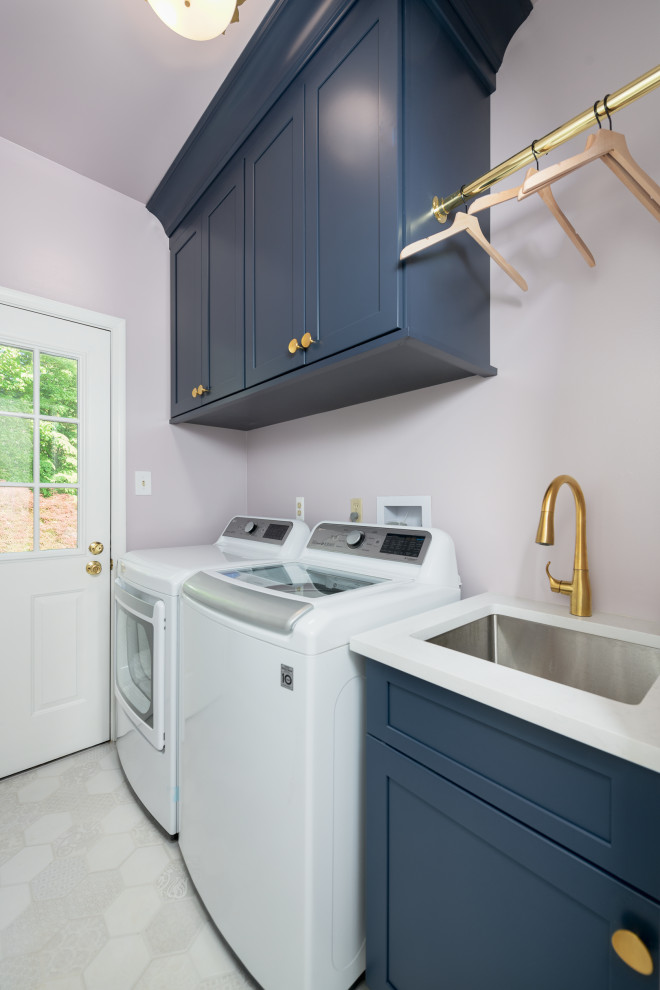 フィラデルフィアにあるお手頃価格の小さなトランジショナルスタイルのおしゃれな洗濯室 (I型、アンダーカウンターシンク、シェーカースタイル扉のキャビネット、青いキャビネット、クオーツストーンカウンター、ピンクのキッチンパネル、紫の壁、磁器タイルの床、左右配置の洗濯機・乾燥機、ベージュの床、白いキッチンカウンター) の写真