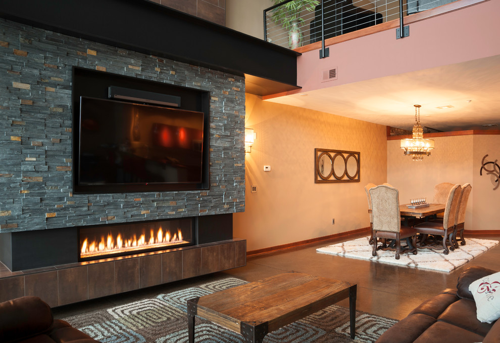 Design ideas for a large industrial loft-style living room in Wichita with beige walls, concrete floors, a ribbon fireplace, a metal fireplace surround and a wall-mounted tv.