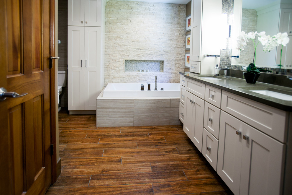 Inspiration for an expansive eclectic master bathroom in St Louis with shaker cabinets, white cabinets, quartzite benchtops, a corner tub, an open shower, gray tile, stone tile and porcelain floors.