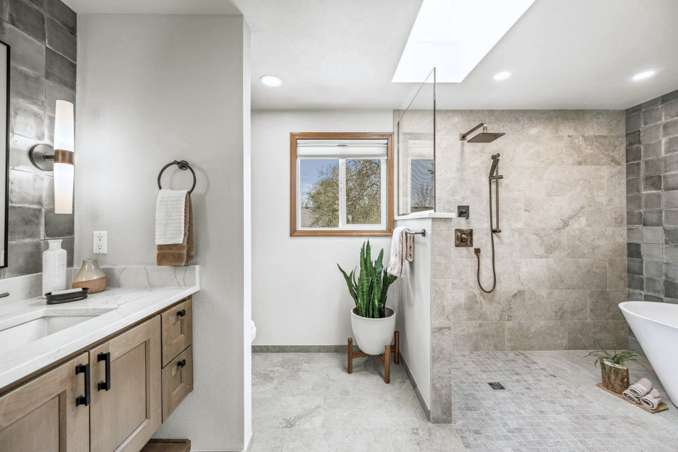 Klassisk inredning av ett mellanstort vit vitt badrum, med möbel-liknande, skåp i mellenmörkt trä, ett fristående badkar, en kantlös dusch, en toalettstol med separat cisternkåpa, grön kakel, keramikplattor, grå väggar, klinkergolv i porslin, ett undermonterad handfat, bänkskiva i kvarts, beiget golv och med dusch som är öppen
