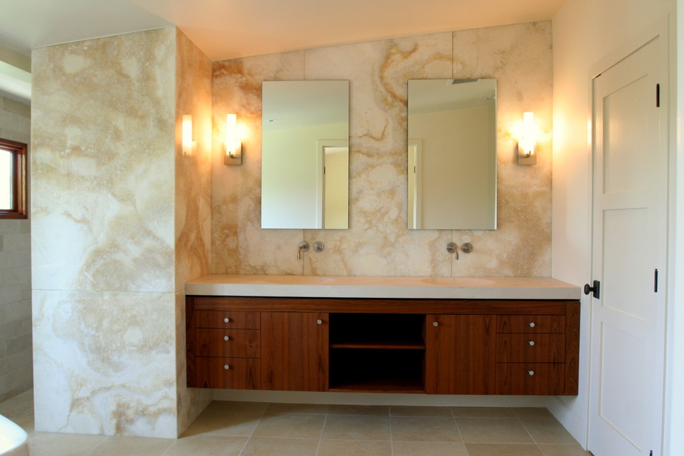 Inspiration for a contemporary master bathroom in Los Angeles with an integrated sink, flat-panel cabinets, medium wood cabinets, limestone benchtops, a freestanding tub, an open shower, beige tile, stone slab, white walls and limestone floors.