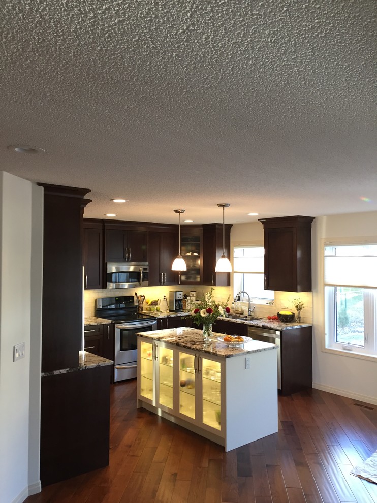 Example of a mid-sized classic u-shaped dark wood floor and brown floor eat-in kitchen design in Calgary with an undermount sink, shaker cabinets, dark wood cabinets, granite countertops, white backsplash, subway tile backsplash, stainless steel appliances and an island