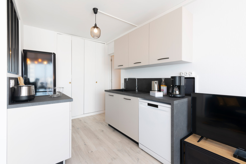Inspiration for a small contemporary single-wall open plan kitchen in Nancy with laminate floors, white floors, a submerged sink, beaded cabinets, white cabinets, composite countertops, black splashback, no island and grey worktops.