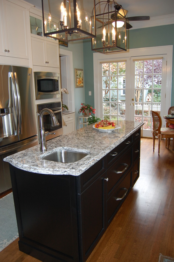Example of a transitional u-shaped eat-in kitchen design in Raleigh with an undermount sink, recessed-panel cabinets, white cabinets, quartzite countertops, white backsplash, subway tile backsplash and stainless steel appliances