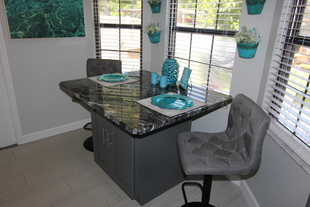 Example of a mid-sized transitional galley porcelain tile and gray floor eat-in kitchen design in Orlando with a single-bowl sink, shaker cabinets, white cabinets, granite countertops, gray backsplash, subway tile backsplash, stainless steel appliances and no island