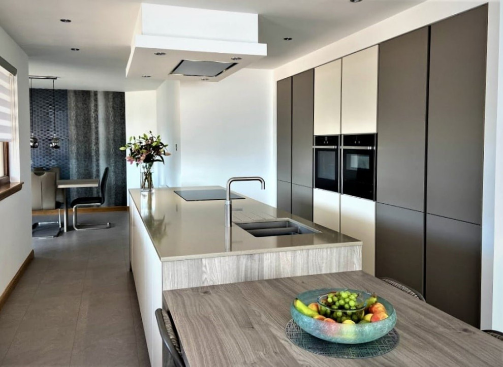 Idee per una cucina moderna di medie dimensioni con lavello sottopiano, ante lisce, ante bianche, top in quarzite, elettrodomestici neri, pavimento grigio e top marrone