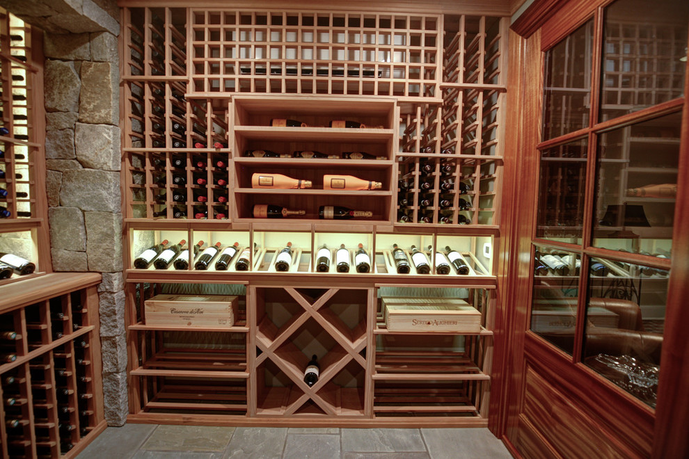 This is an example of a large traditional wine cellar in Charlotte with travertine floors and storage racks.