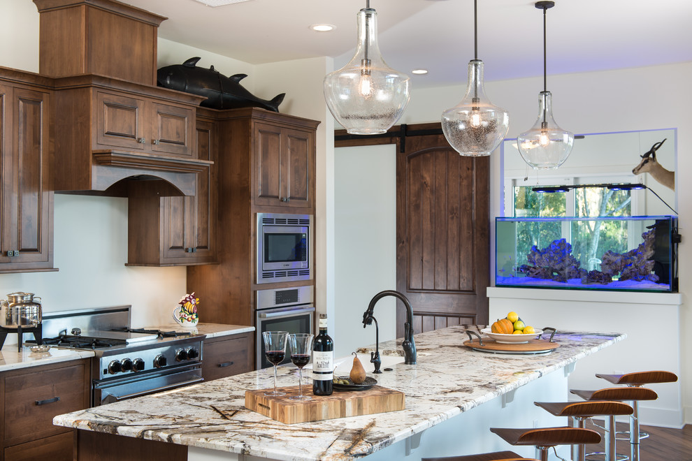 Design ideas for a traditional kitchen in Orlando with raised-panel cabinets, dark wood cabinets, stainless steel appliances and with island.