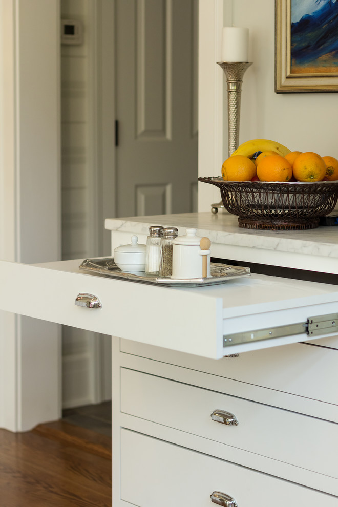 Transitional light wood floor kitchen photo in New York with two islands, a farmhouse sink, white cabinets, marble countertops, white backsplash, porcelain backsplash and stainless steel appliances
