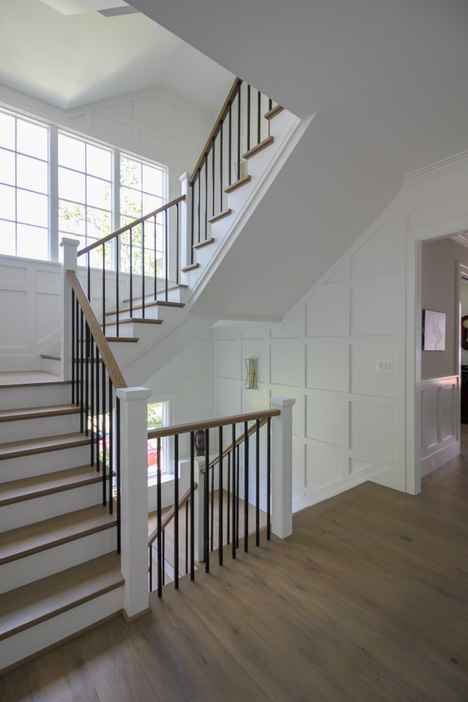 Idées déco pour un grand escalier classique en U avec des marches en bois, des contremarches en bois, un garde-corps en bois, boiseries et palier.