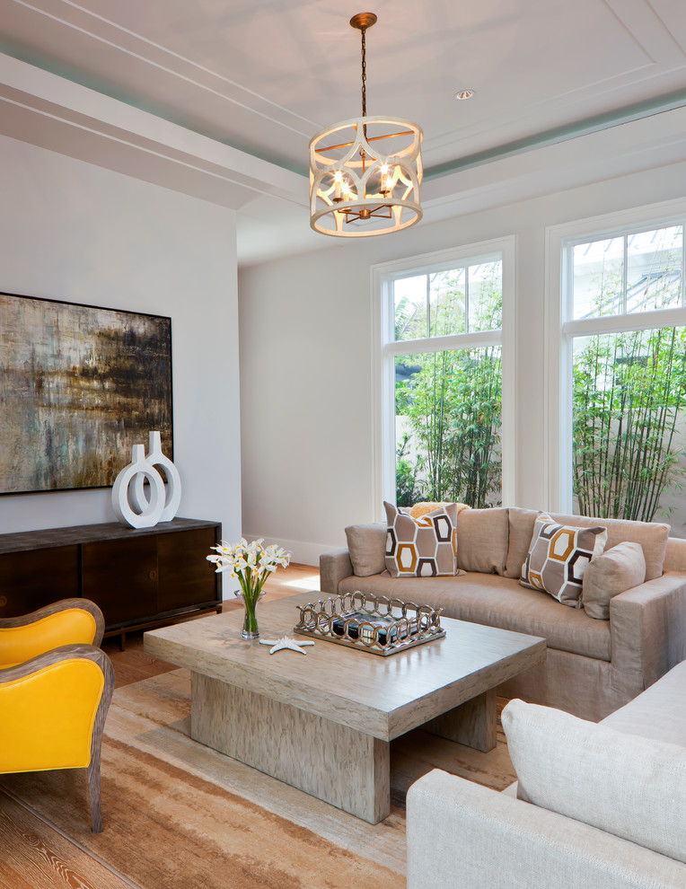 This is an example of a transitional family room in Miami with white walls and medium hardwood floors.