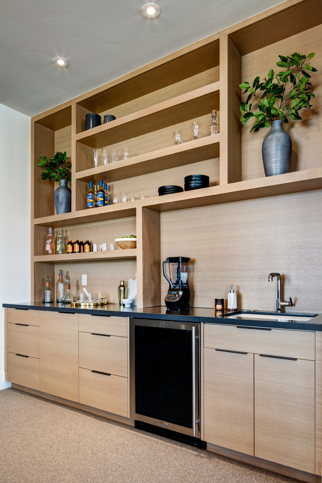 Inspiration for a large contemporary single-wall wet bar in Salt Lake City with an undermount sink, flat-panel cabinets, light wood cabinets, quartz benchtops, brown splashback, timber splashback, carpet, grey floor and black benchtop.