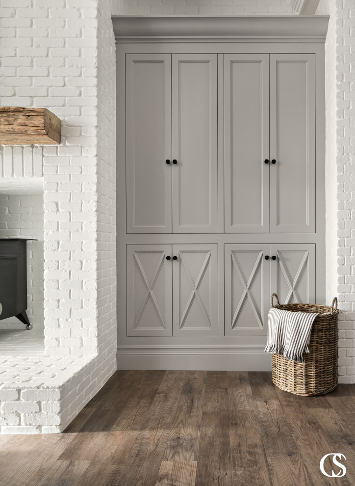 Exemple d'un salon chic avec une salle de réception, un mur blanc, un sol en bois brun, une cheminée standard, un manteau de cheminée en brique et un mur en parement de brique.
