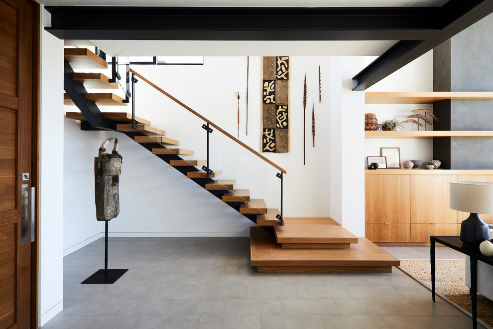 Inspiration for a contemporary wood l-shaped staircase in Los Angeles with open risers and glass railing.