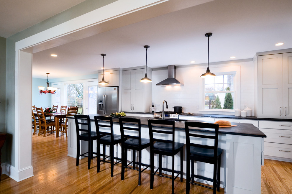 Inspiration for a transitional medium tone wood floor kitchen remodel in Philadelphia with an island, white cabinets, soapstone countertops and stainless steel appliances