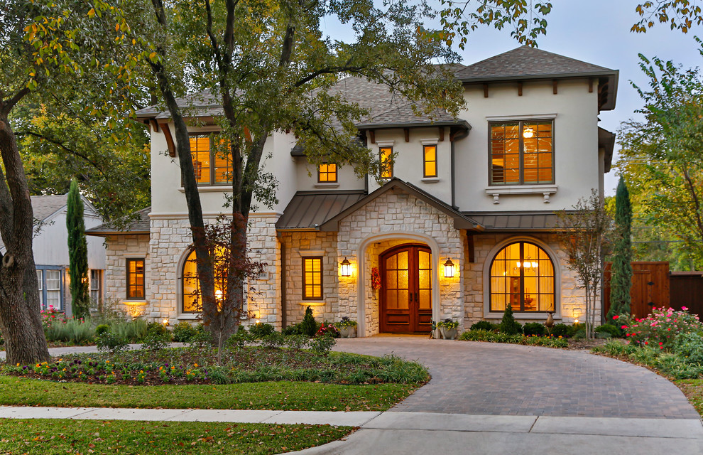Design ideas for a large mediterranean two-storey exterior in Dallas with stone veneer and a mixed roof.