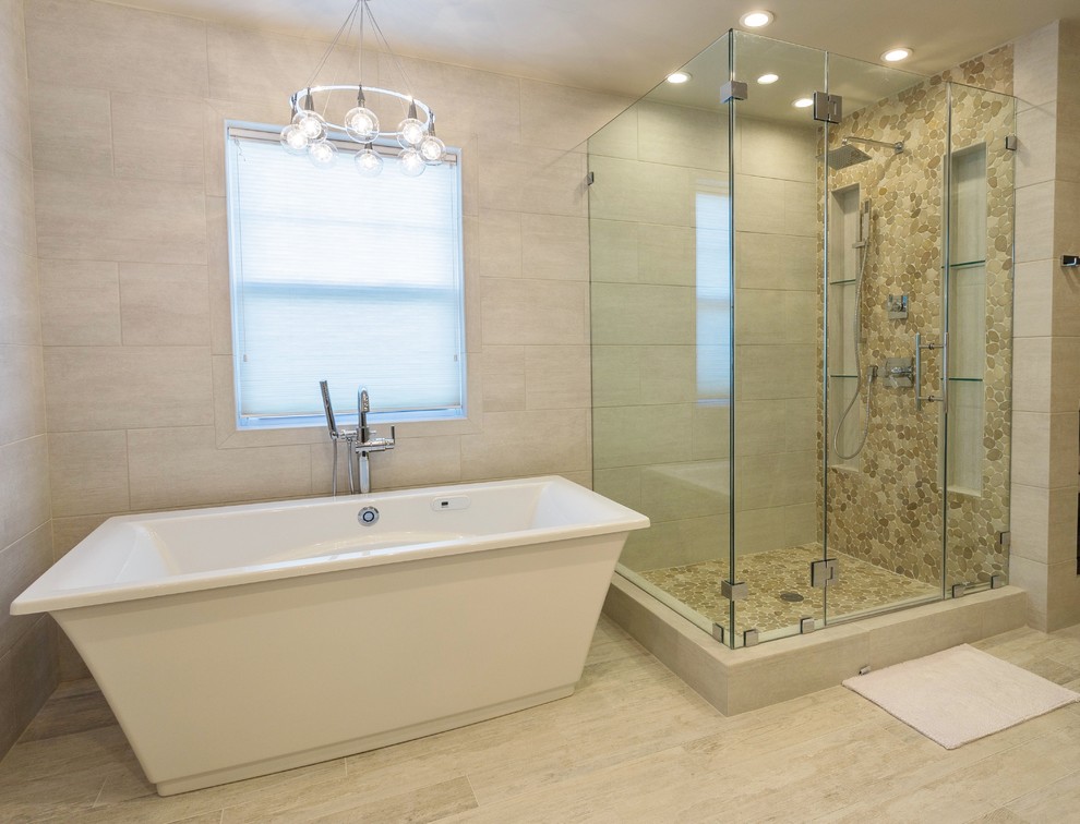 Design ideas for a large modern master bathroom in New York with a freestanding tub, a corner shower, beige tile, pebble tile, beige walls and light hardwood floors.