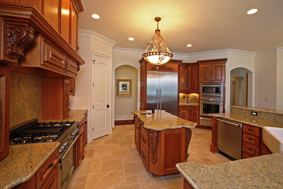 Photo of a large mediterranean u-shaped eat-in kitchen in Jacksonville with beaded inset cabinets, medium wood cabinets, marble benchtops, stainless steel appliances, with island, a farmhouse sink and travertine floors.