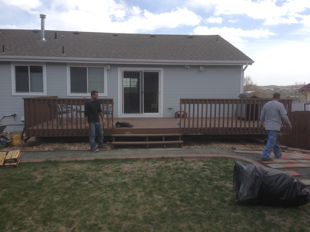 This is an example of a traditional backyard deck in Denver with a roof extension.