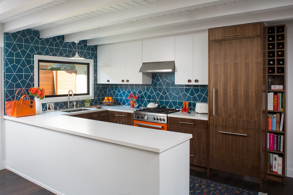 This is an example of a mid-sized midcentury u-shaped eat-in kitchen in San Francisco with an undermount sink, flat-panel cabinets, medium wood cabinets, quartz benchtops, blue splashback, ceramic splashback, coloured appliances, dark hardwood floors, a peninsula, brown floor and white benchtop.