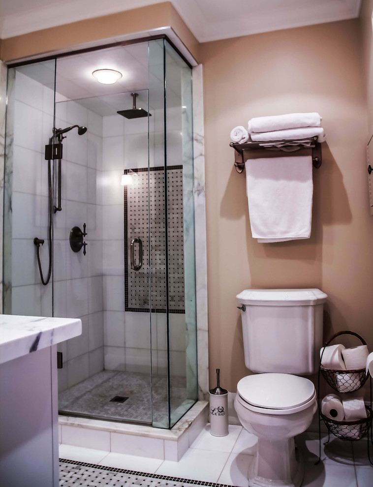 Photo of a small bathroom in Toronto with flat-panel cabinets, a corner shower, white tile and beige walls.