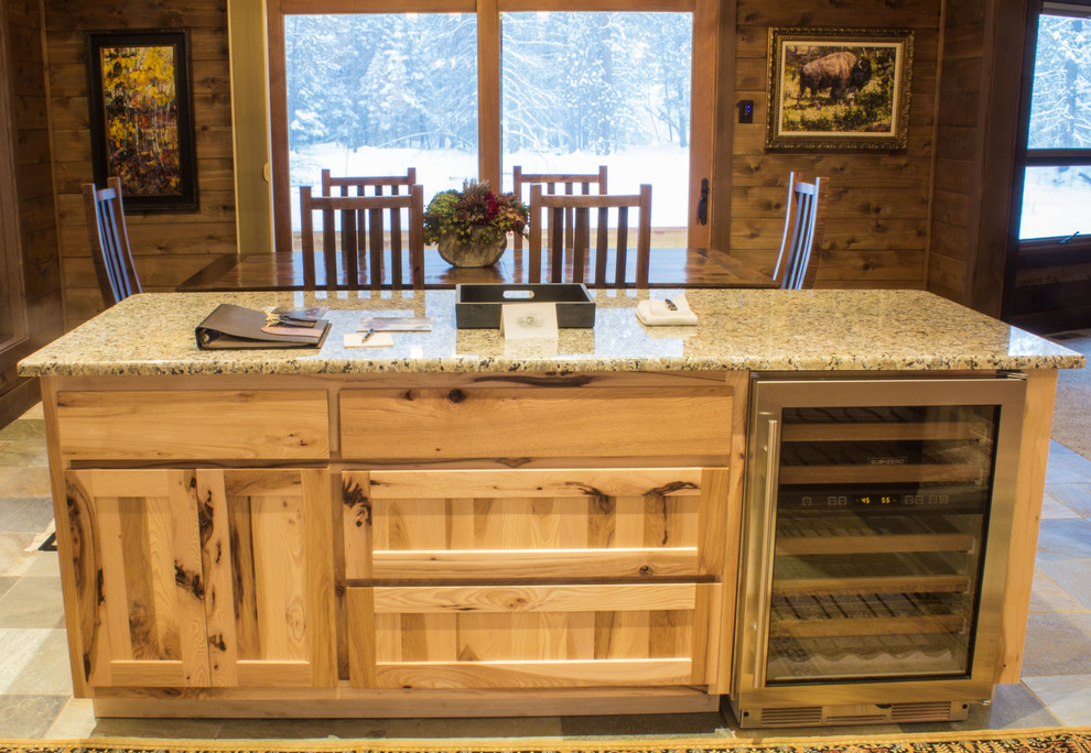 Example of a mid-sized mountain style l-shaped slate floor and gray floor eat-in kitchen design with flat-panel cabinets, medium tone wood cabinets, granite countertops, stainless steel appliances, an island and an undermount sink