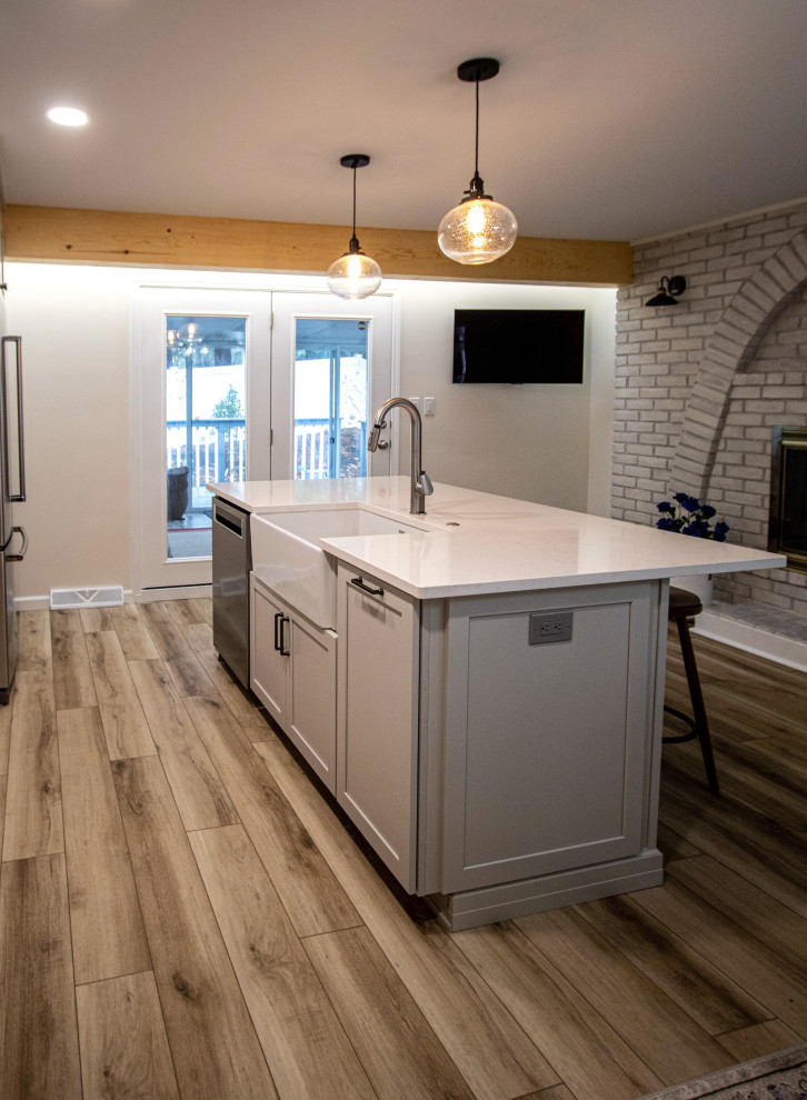 Idéer för att renovera ett stort vintage vit vitt kök, med en undermonterad diskho, skåp i shakerstil, grå skåp, bänkskiva i kvarts, vitt stänkskydd, stänkskydd i keramik, rostfria vitvaror, vinylgolv, en köksö och brunt golv