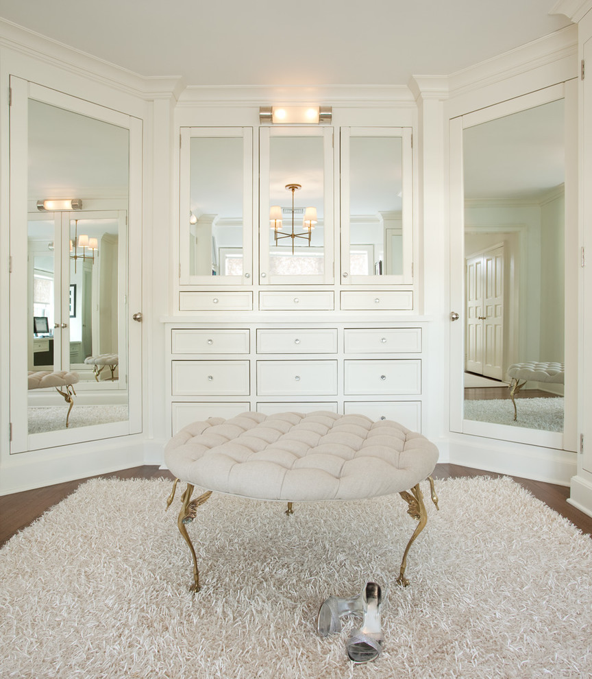 Inspiration for an expansive traditional dressing room in New York with white cabinets and dark hardwood floors.