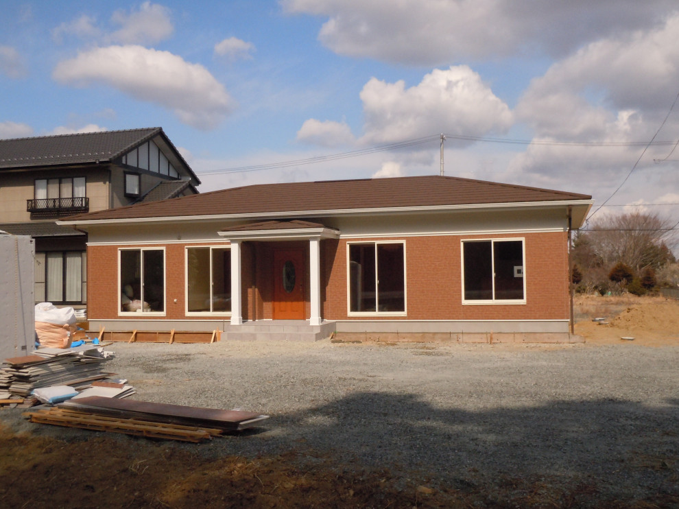 他の地域にある小さなトラディショナルスタイルのおしゃれな家の外観 (混合材サイディング、オレンジの外壁、ウッドシングル張り) の写真