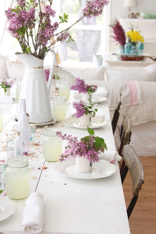 真っ白なテーブルに春らしいお花を飾り、ぱらぱら落ちた花びらからもあたたかさを感じるテーブルに。お花から漂う香り・天然なアロマに癒されそうですね♡