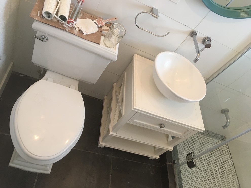 Photo of a small modern 3/4 bathroom in Denver with furniture-like cabinets, white cabinets, a curbless shower, a two-piece toilet, white tile, ceramic tile, white walls, slate floors, a vessel sink, concrete benchtops, black floor, a hinged shower door and grey benchtops.