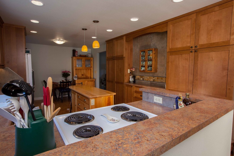 Example of a mid-sized transitional l-shaped eat-in kitchen design in Seattle with shaker cabinets, medium tone wood cabinets and an island