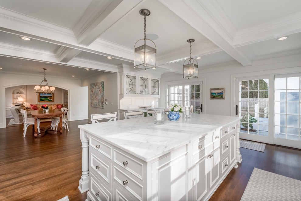 Open concept kitchen - large transitional l-shaped medium tone wood floor and brown floor open concept kitchen idea in Milwaukee with an undermount sink, recessed-panel cabinets, white cabinets, marble countertops, white backsplash, marble backsplash, stainless steel appliances, an island and white countertops