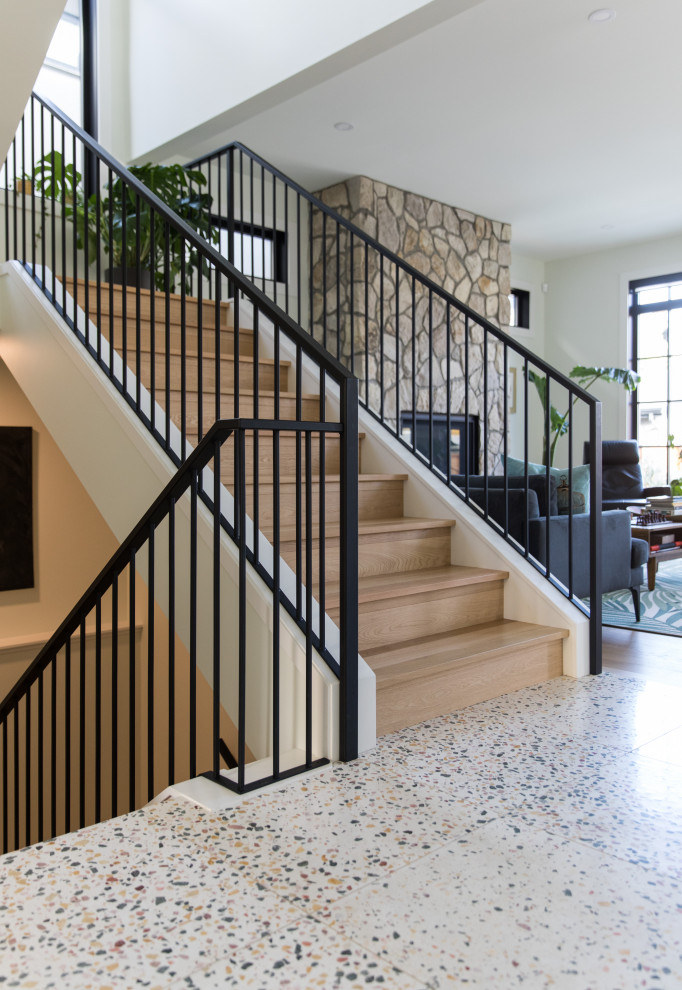 Ejemplo de escalera recta vintage grande con escalones de madera, contrahuellas de madera y barandilla de metal